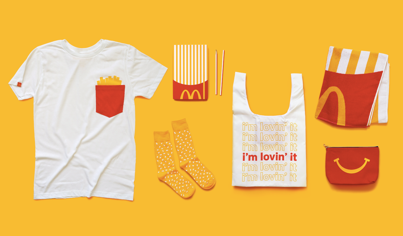 McDonald's merchandise—a tshirt, socks, plastic bag, towel, pencil case, and pouch—in the signature McDonald's yellow and red colors
